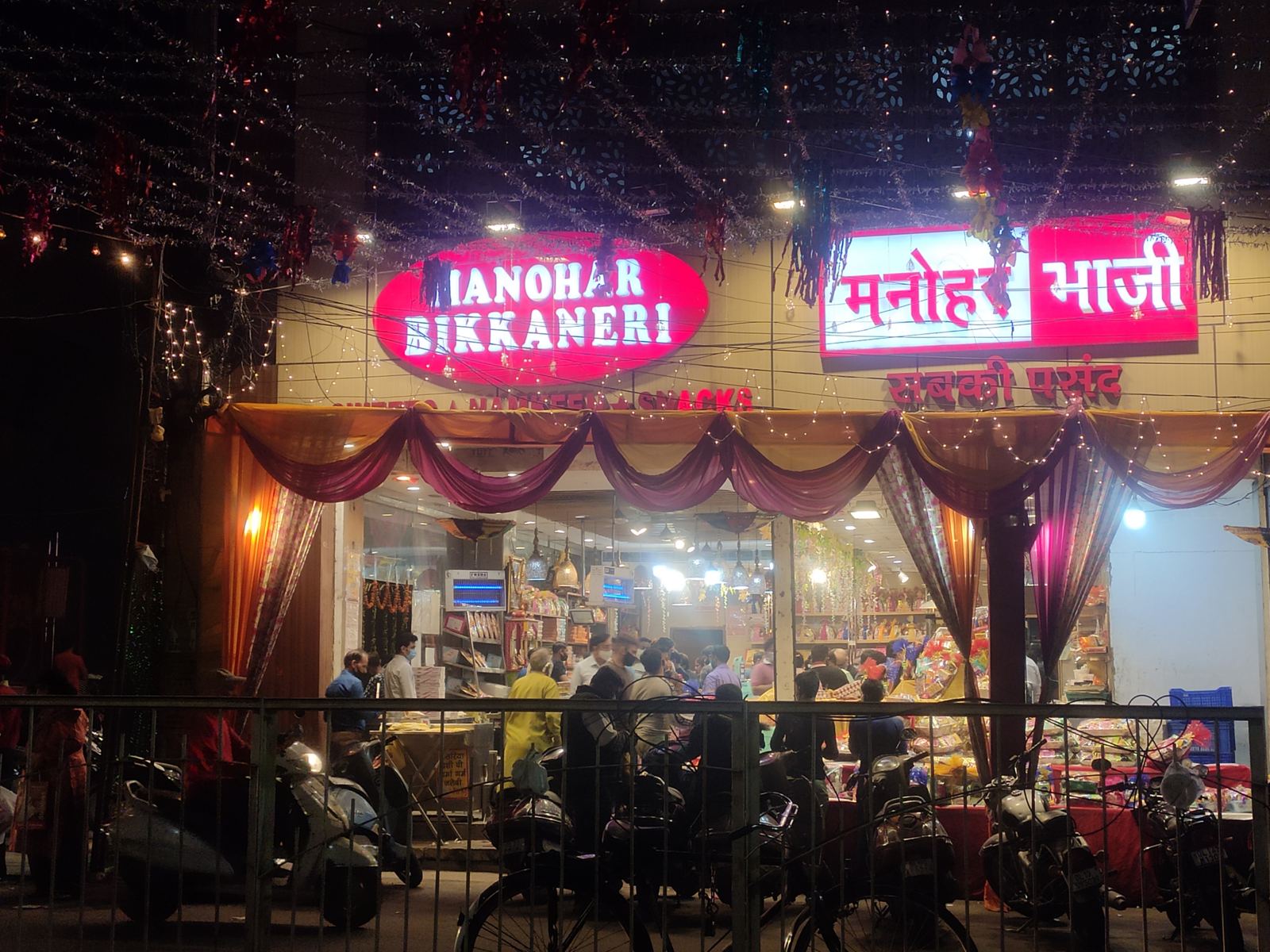 Raat mein roshni se jagmagati mithai ki dukaan
